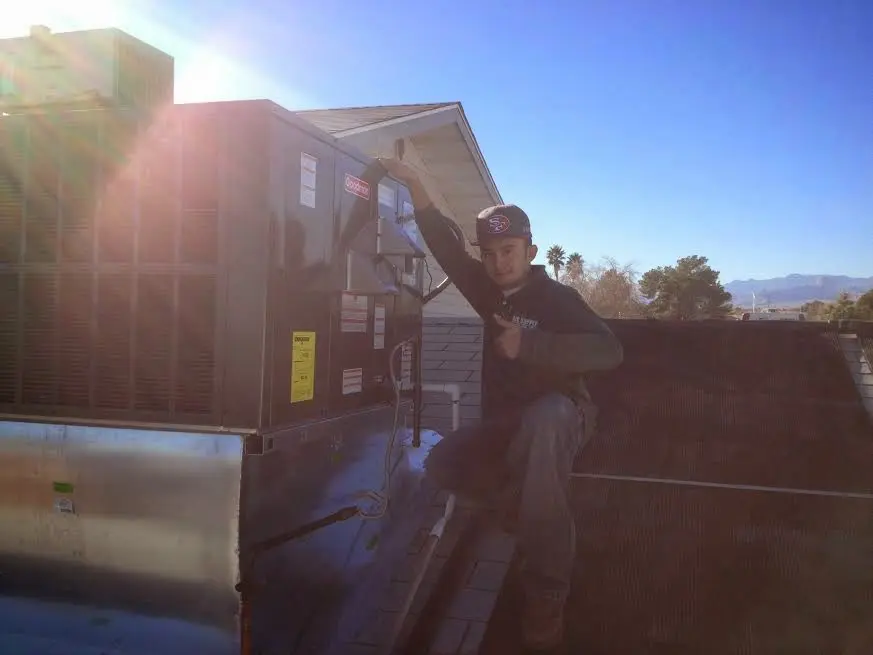 HVAC technician performing HVAC Inspection on a rooftop unit in Blackwell
